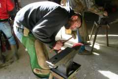 Student shaping a hot shoe for a horse
