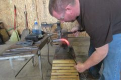 Ed making a handmade horseshoe